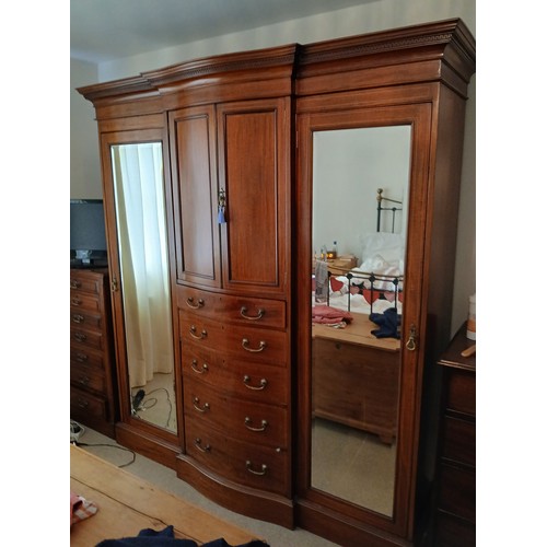 140 - A Edwardian mahogany inlaid compactum/wardrobe with mirrored doors to either side of central cupboar... 