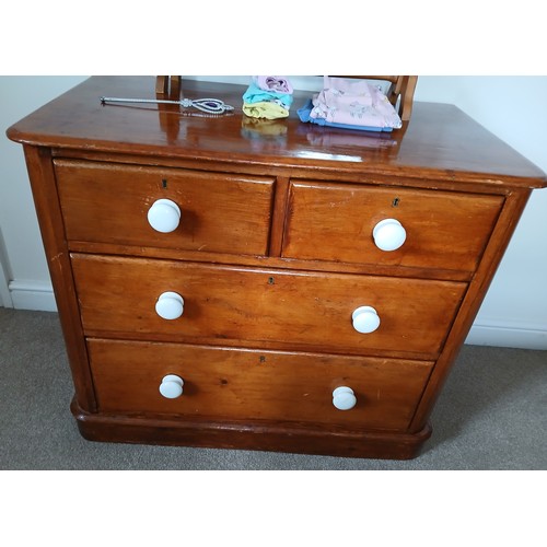 145 - A 19thC pine chest of two short over two long drawers with white ceramic handles. 91cm x 53cm x 76cm... 