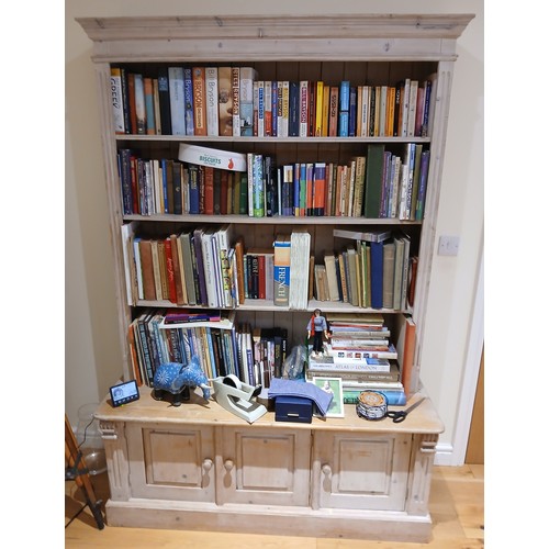 148 - A painted pine bookcase with cupboards to base. 135cm w x 49cm d x 56cm h at base x 24cm deep at she... 