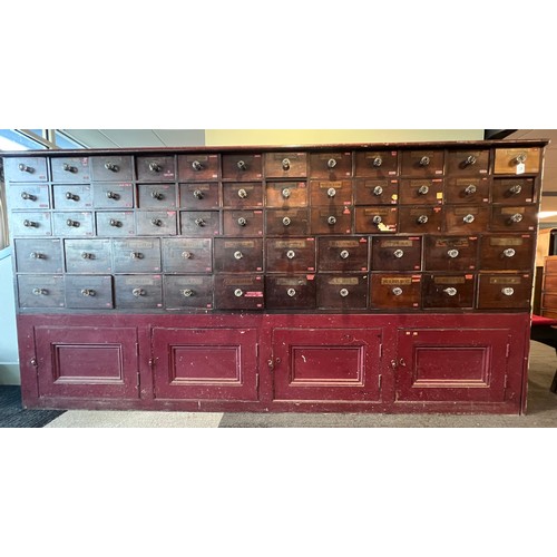 64 - Nineteenth century drug run/drawers, multiple drawers over cupboards to base. 268cm l x 137cm h x 30... 