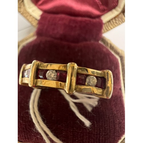 549 - A nine carat gold ring set with three diamonds and rubies. Size L. Weight 3.1gm.