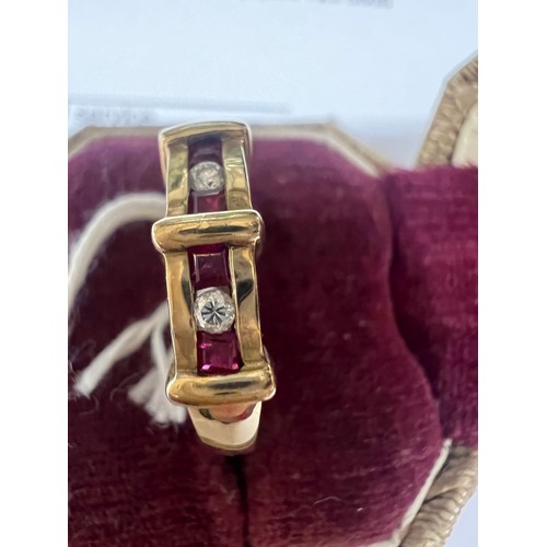 549 - A nine carat gold ring set with three diamonds and rubies. Size L. Weight 3.1gm.