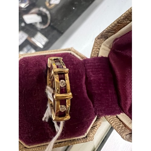 549 - A nine carat gold ring set with three diamonds and rubies. Size L. Weight 3.1gm.