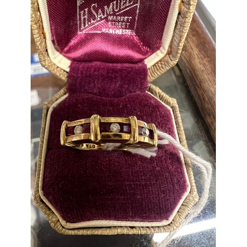 549 - A nine carat gold ring set with three diamonds and rubies. Size L. Weight 3.1gm.