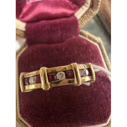 549 - A nine carat gold ring set with three diamonds and rubies. Size L. Weight 3.1gm.