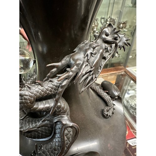 1011 - A Japanese bronze dragon vase, the dragon clutching rock crystal tama. 33cm h.