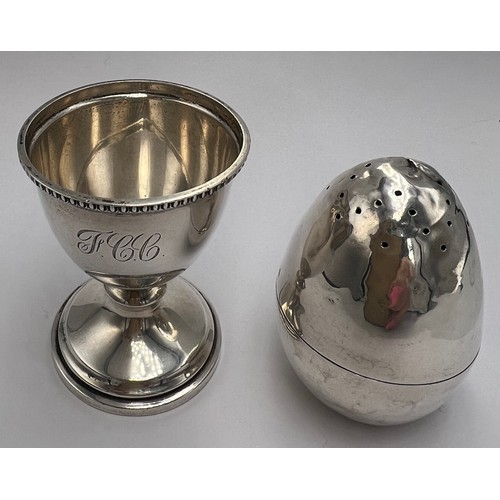 22 - Hallmarked silver egg cup, Birmingham 1947, 6cm h together with an egg shaped pepper pot with weight... 