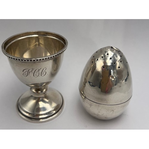 22 - Hallmarked silver egg cup, Birmingham 1947, 6cm h together with an egg shaped pepper pot with weight... 