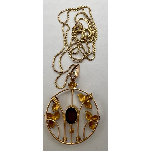 20 - A nine carat gold pendant set with central garnet and seed pearls suspended on an 18 carat gold chai... 