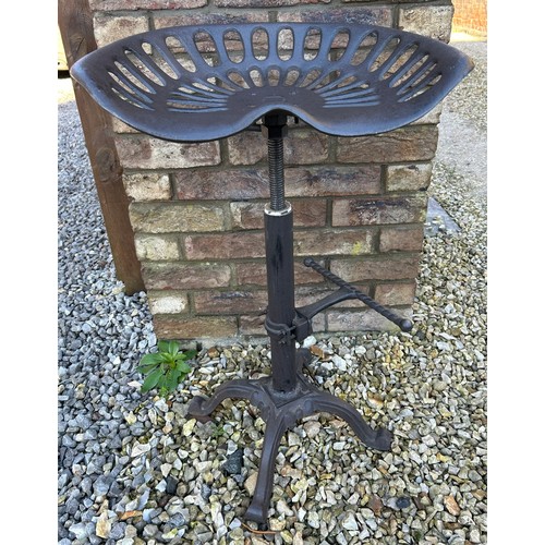 310 - Two cast iron tractor seat stools with adjustable swivel tops.