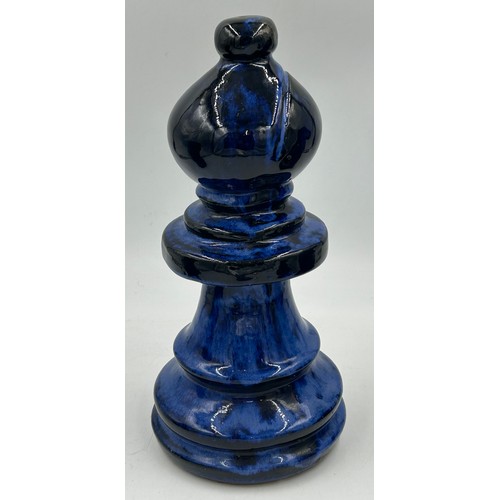 311 - A set of four oversized terracotta chess pieces in electric blue glaze. Tallest 36cm.