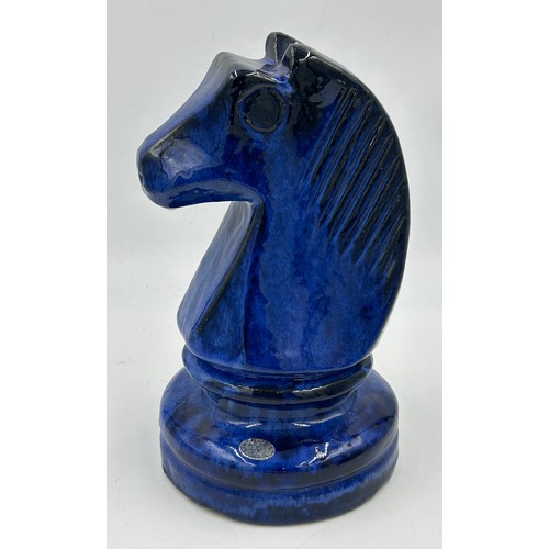 311 - A set of four oversized terracotta chess pieces in electric blue glaze. Tallest 36cm.