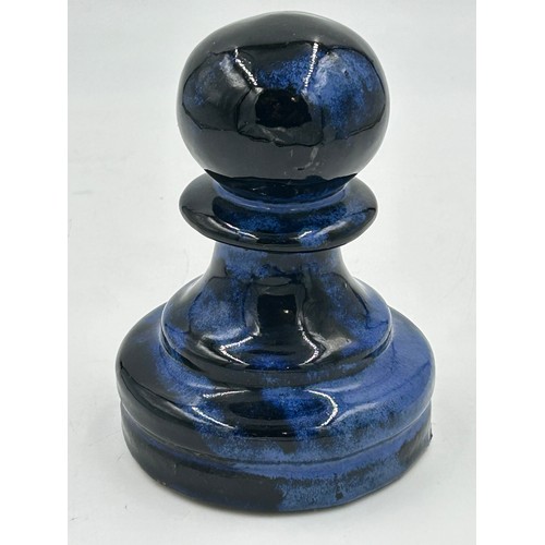 311 - A set of four oversized terracotta chess pieces in electric blue glaze. Tallest 36cm.