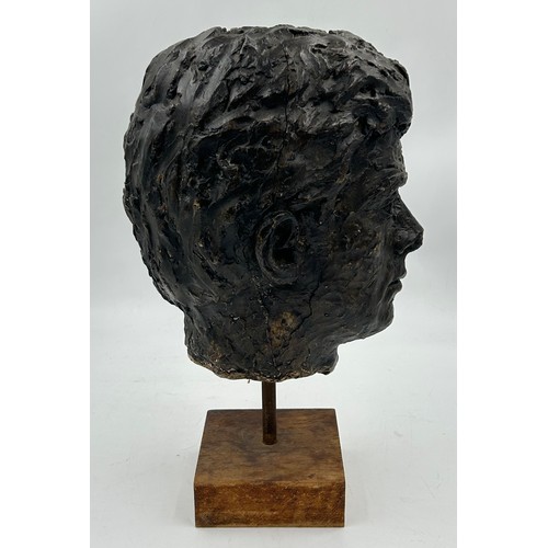 352 - A 1960’s plaster bust of president JFK, mounted on a wooden stand. 43cm h.