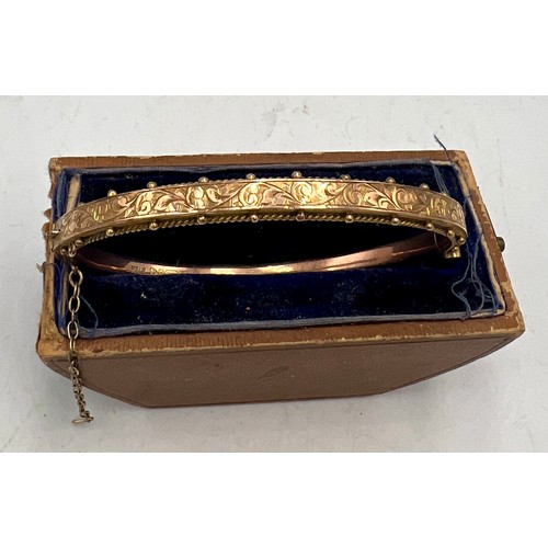 521 - A 9 carat gold hinged bangle. Weight 7.4gm.