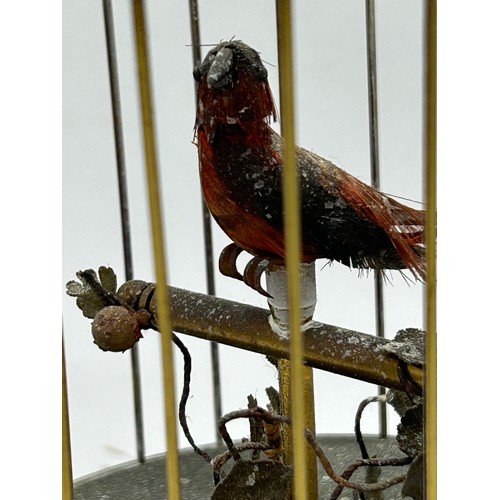 1165 - A 20thC Musical Automated Bird in a wire cage standing on a brass base edged with floral decoration.