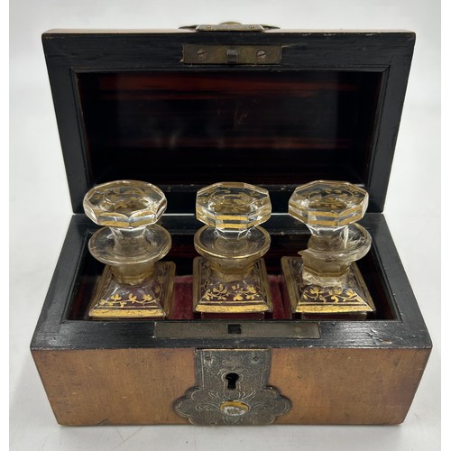 901 - A 19thC domed brass bound box containing three glass perfume bottles with gilt decoration. Labels to... 