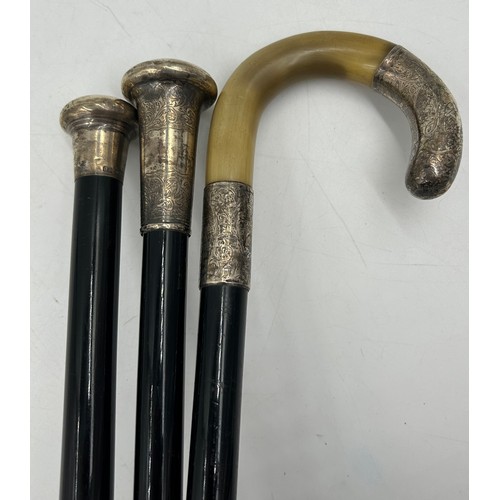 1167 - Two hallmarked silver topped ebonised walking canes and a horn handled walking stick with hallmarked... 