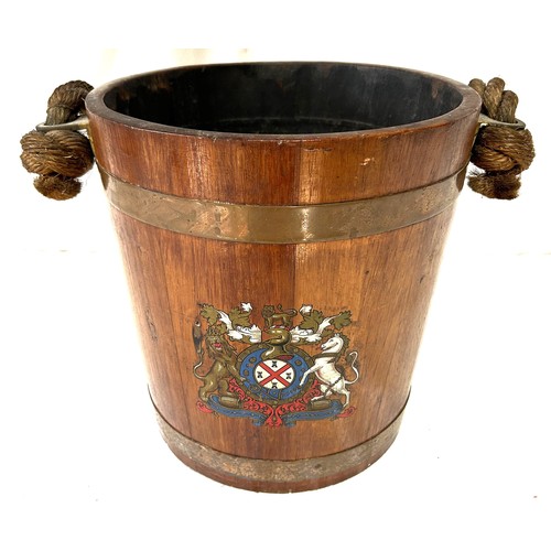 1172 - An oak naval fire bucket with insignia to the front, two copper bands and a rope handle with leather... 