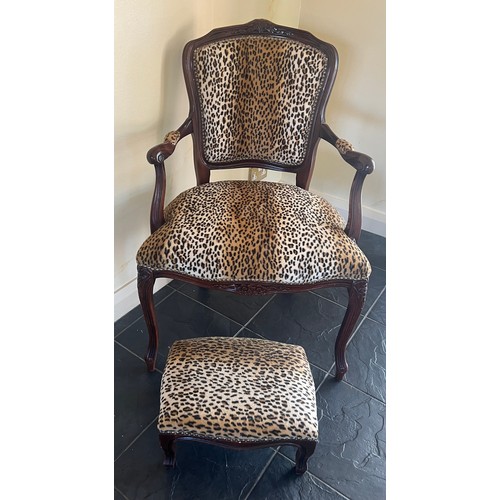 28 - A leopard print upholstered armchair and matching footstool. Height to back 89cm.