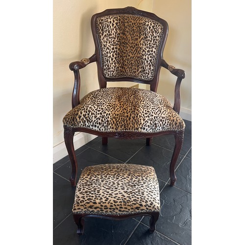 28 - A leopard print upholstered armchair and matching footstool. Height to back 89cm.