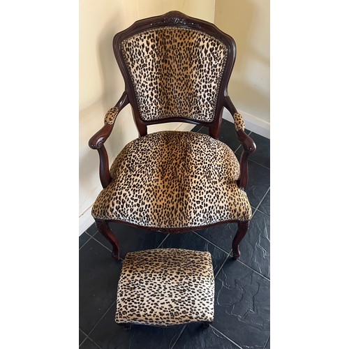 28 - A leopard print upholstered armchair and matching footstool. Height to back 89cm.