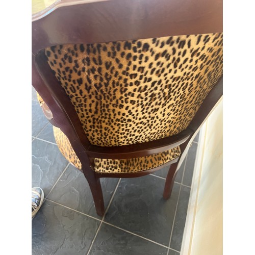 28 - A leopard print upholstered armchair and matching footstool. Height to back 89cm.