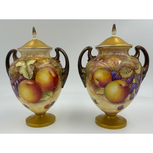 369 - A pair of Royal Worcester porcelain urn shaped vases painted with assorted fruit, one signed C. Hugh... 