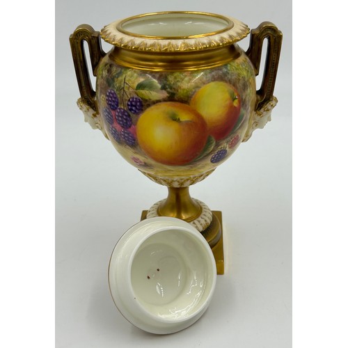 376 - A pair of Royal Worcester twin handled lidded urns with masks to sides on a circular foot with a squ... 