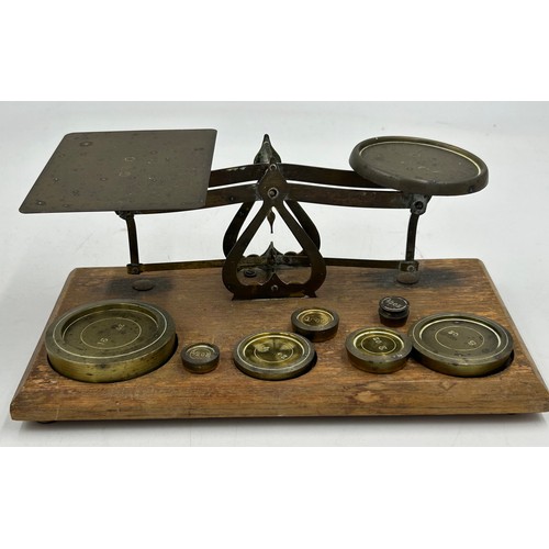 911 - Brass items to include a set of postal scales with complete weights, a terret and a countertop bell.... 