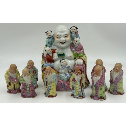 932 - A mid 20thC hand painted porcelain figure of a happy Buddha with five children measuring approx 20cm... 