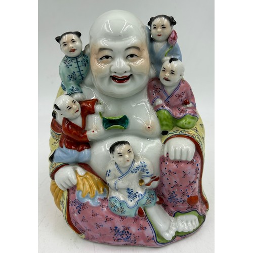 932 - A mid 20thC hand painted porcelain figure of a happy Buddha with five children measuring approx 20cm... 