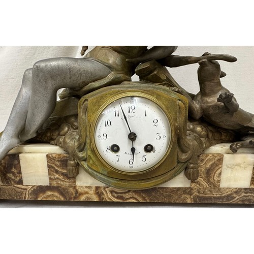 985 - An onyx mantel clock with a bronze figure of a girl and playing dog, marked Marseille, comes with ke... 