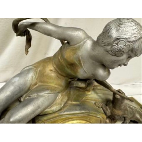 985 - An onyx mantel clock with a bronze figure of a girl and playing dog, marked Marseille, comes with ke... 