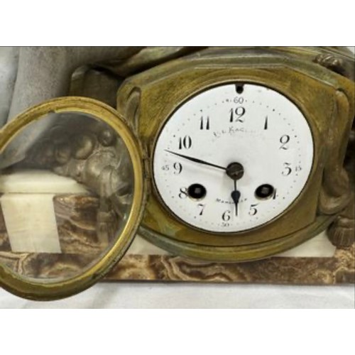 985 - An onyx mantel clock with a bronze figure of a girl and playing dog, marked Marseille, comes with ke... 