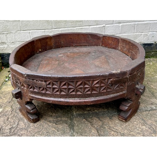 34 - An early 20thC Indian Chakki circular teak grinding table. Longest diameter 71cm w x 27cm h.