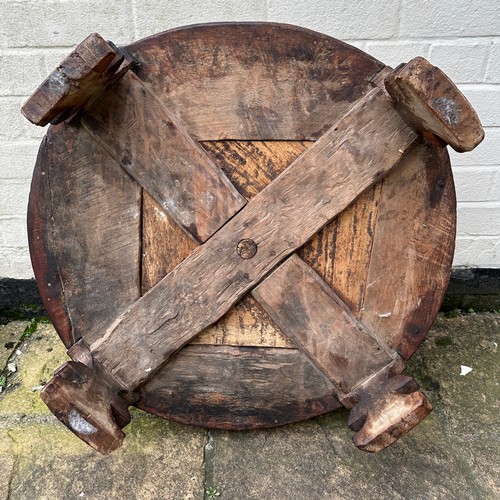 34 - An early 20thC Indian Chakki circular teak grinding table. Longest diameter 71cm w x 27cm h.