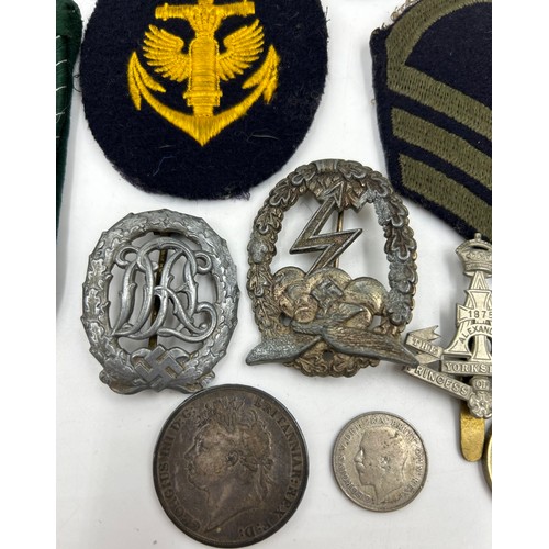 1004 - A selection of military badges in a Huntley and Palmers biscuit tin to include R.A.F beret badges, D... 