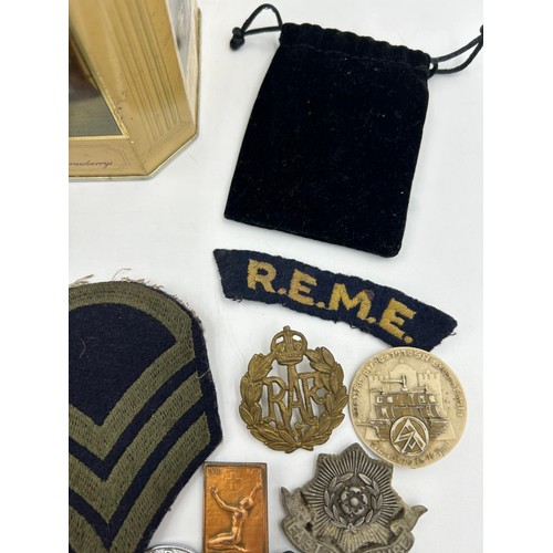 1004 - A selection of military badges in a Huntley and Palmers biscuit tin to include R.A.F beret badges, D... 