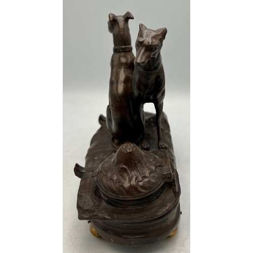 1181 - A cold painted bronze musical inkwell with seated and standing dogs to top. 14cm x 7cm.