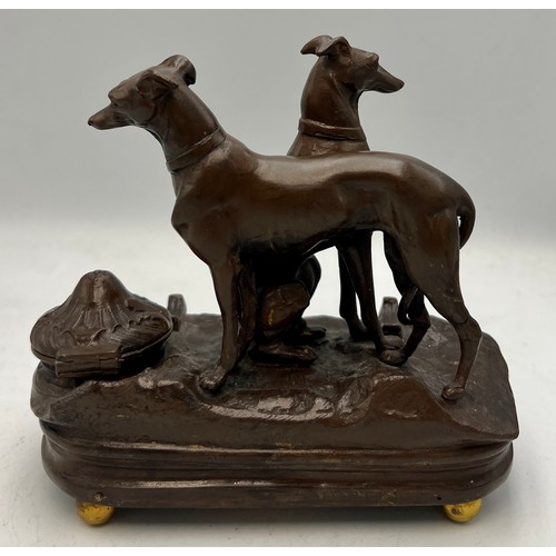 1181 - A cold painted bronze musical inkwell with seated and standing dogs to top. 14cm x 7cm.