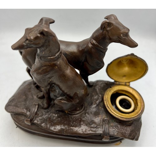 1181 - A cold painted bronze musical inkwell with seated and standing dogs to top. 14cm x 7cm.