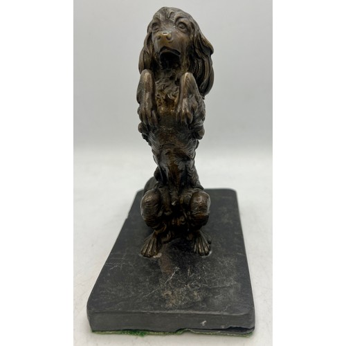 1183 - A bronze dog figure mounted on a slate base. 14cm h.