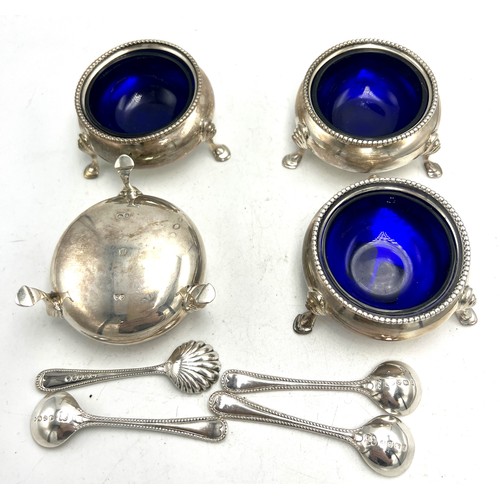 809 - Four silver salts with blue glass liners London 1882, maker Robert Harper and spoons, three London 1... 