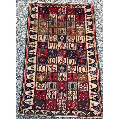 1103 - A red ground wool rug with panel designs. Approx. 167 x 280cm. (not including tassels).