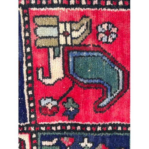 1103 - A red ground wool rug with panel designs. Approx. 167 x 280cm. (not including tassels).