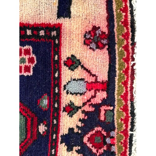 1103 - A red ground wool rug with panel designs. Approx. 167 x 280cm. (not including tassels).