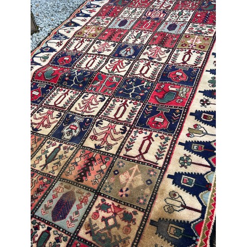 1103 - A red ground wool rug with panel designs. Approx. 167 x 280cm. (not including tassels).