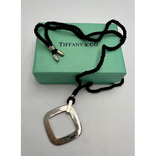 562 - A silver Tiffany square pendant on black silk cord necklace, 60cm l.