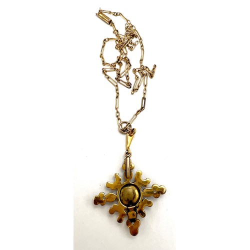 566 - An unmarked yellow metal gem set pendant suspended on an unmarked yellow metal chain, chain 42cm l, ... 